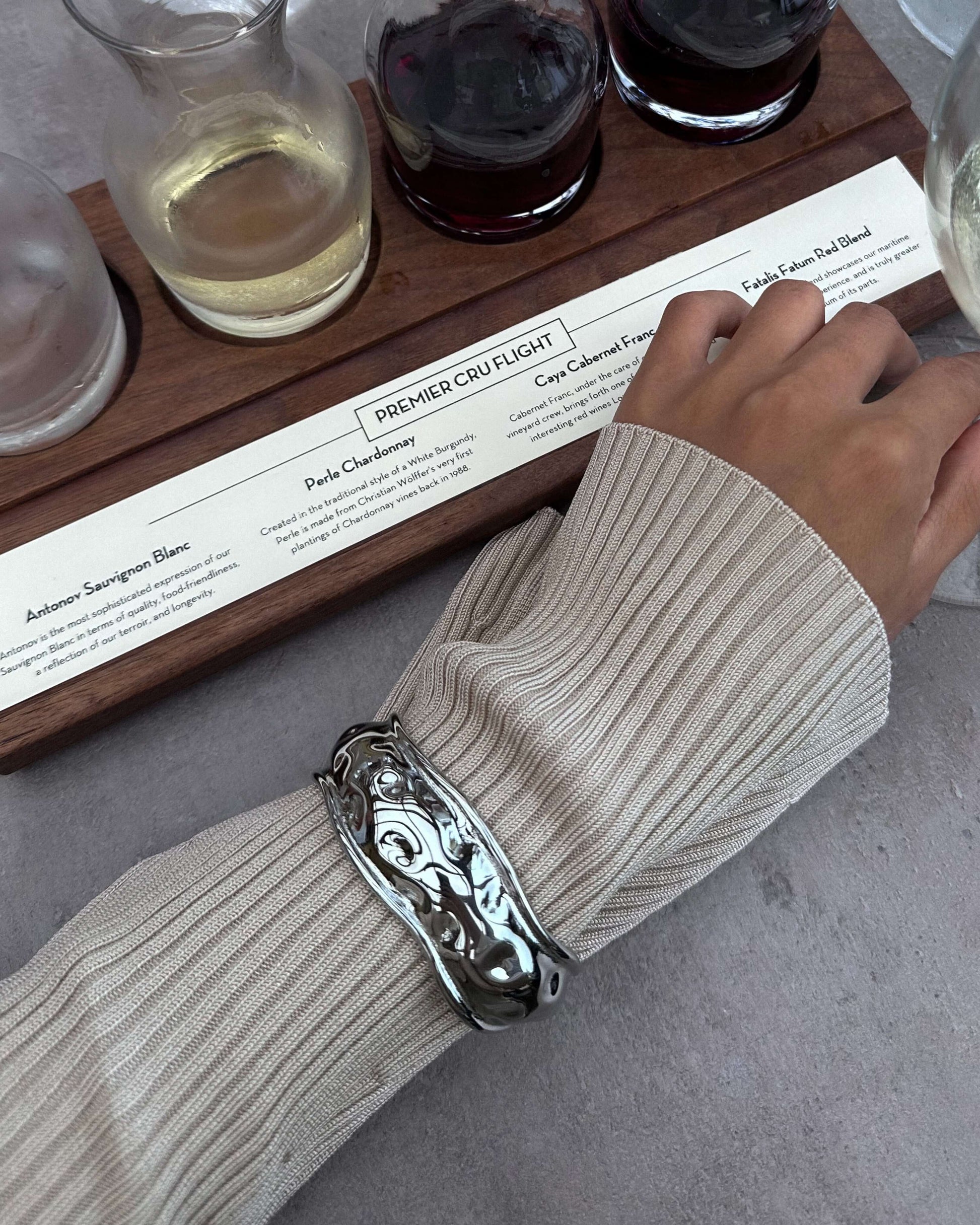 Gold or silver wavy cuff bracelets stacked on wrist, featuring a sculptural organic design with high-polish mirror finish and hammered texture — modern statement bangles crafted from durable Italian metal.