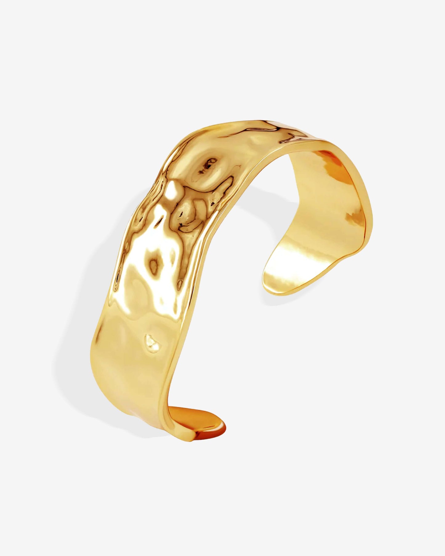 Gold or silver wavy cuff bracelets stacked on wrist, featuring a sculptural organic design with high-polish mirror finish and hammered texture — modern statement bangles crafted from durable Italian metal.