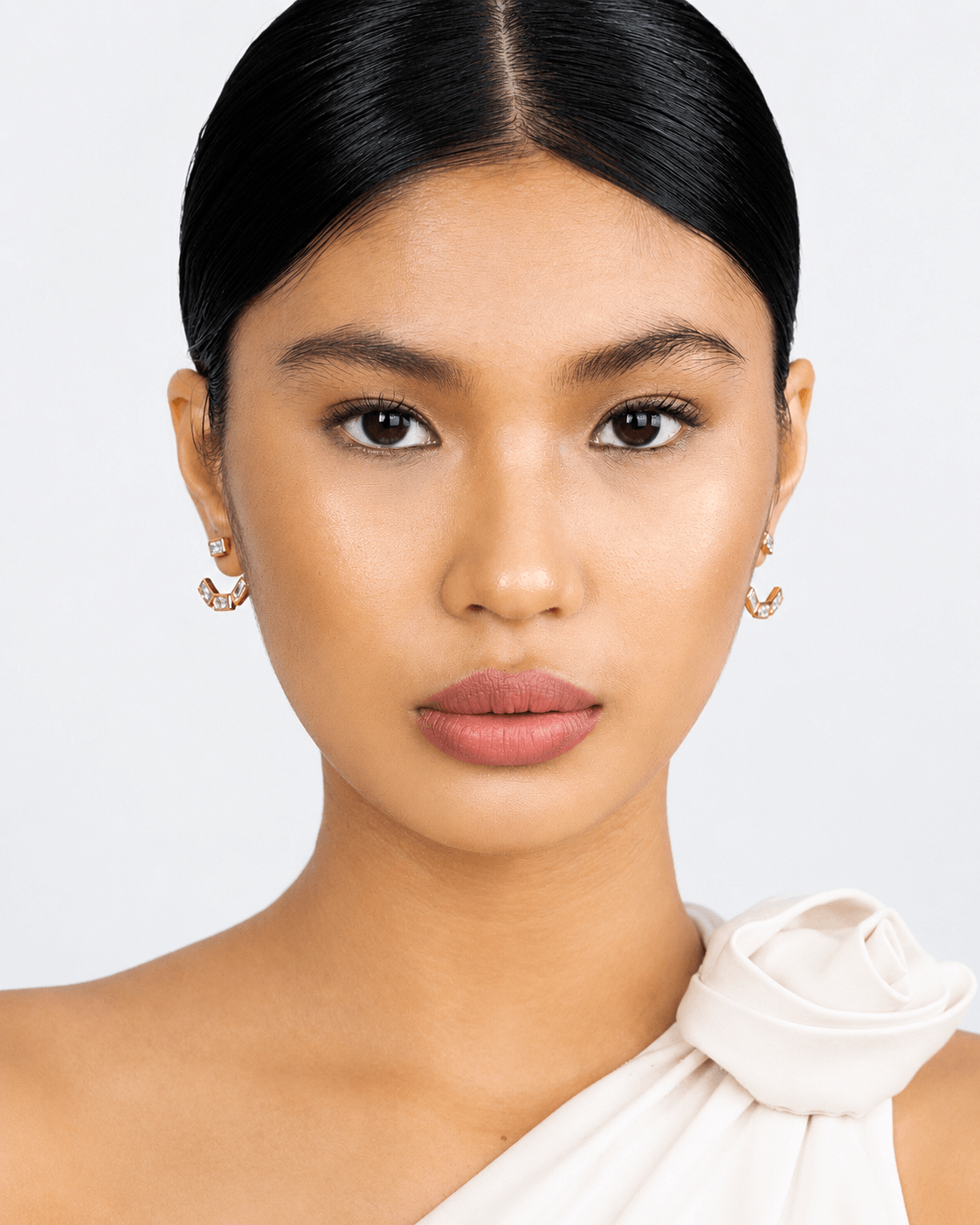 Detachable baguette zircon ear jacket earrings in gold finish displayed on a soft neutral background. Modern geometric stud earrings with removable ear jacket design, featuring sparkling rectangular CZ stones and minimalist contemporary styling for everyday wear and statement looks.